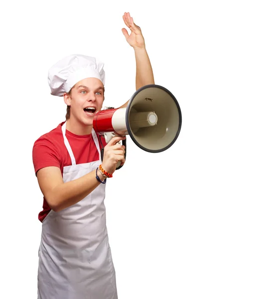 Portrait de jeune cuisinier homme criant avec mégaphone sur ba blanc — Photo