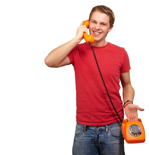 Portrait of young man talking with vintage telephone over white Stock Photo