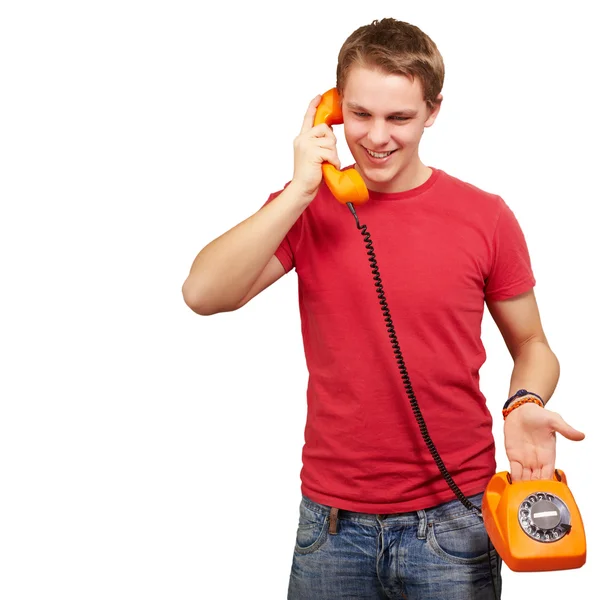 Portrait of young man talking on vintage telephone over white ba Royalty Free Stock Images