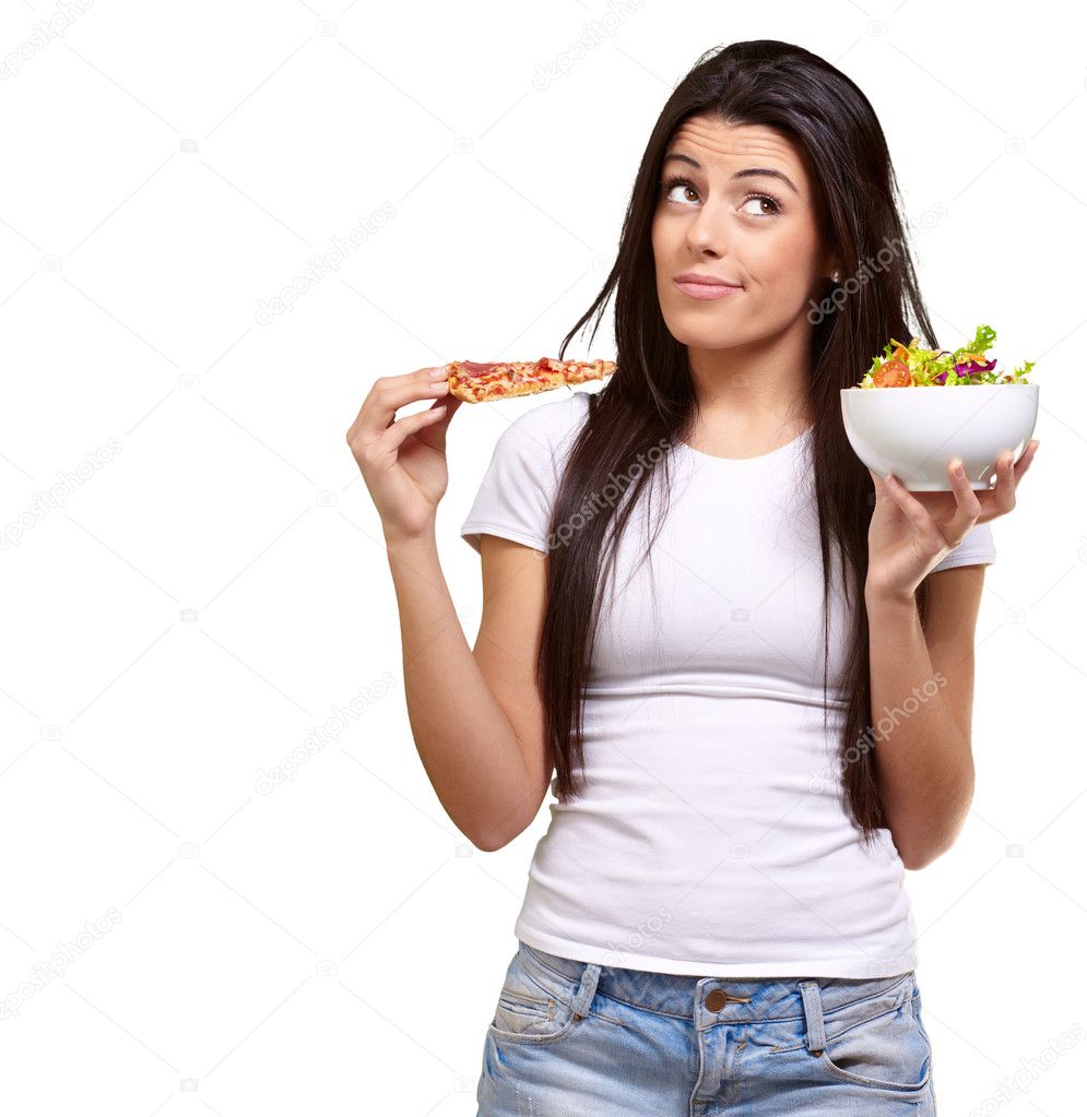 Portrait of young woman choosing pizza or salad against a white
