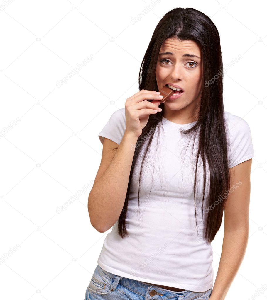 Portrait of young woman eating chocolate bar over white backgrou