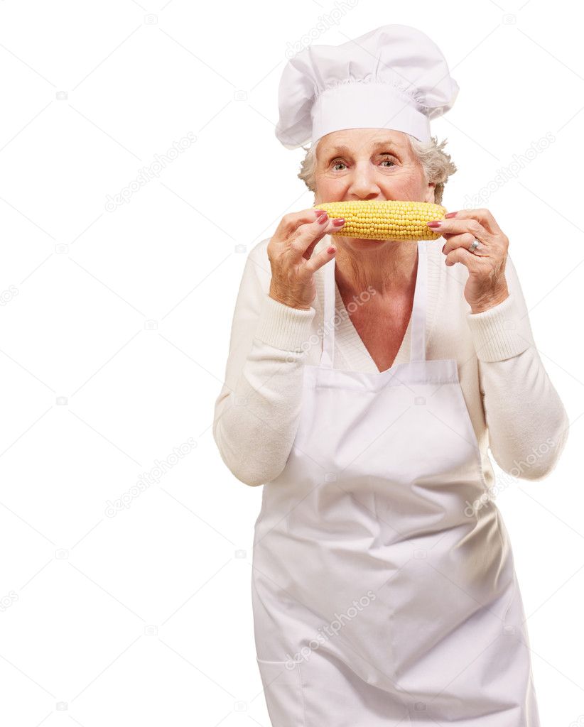 Portrait of senior cook woman eating corn cob over white backgro