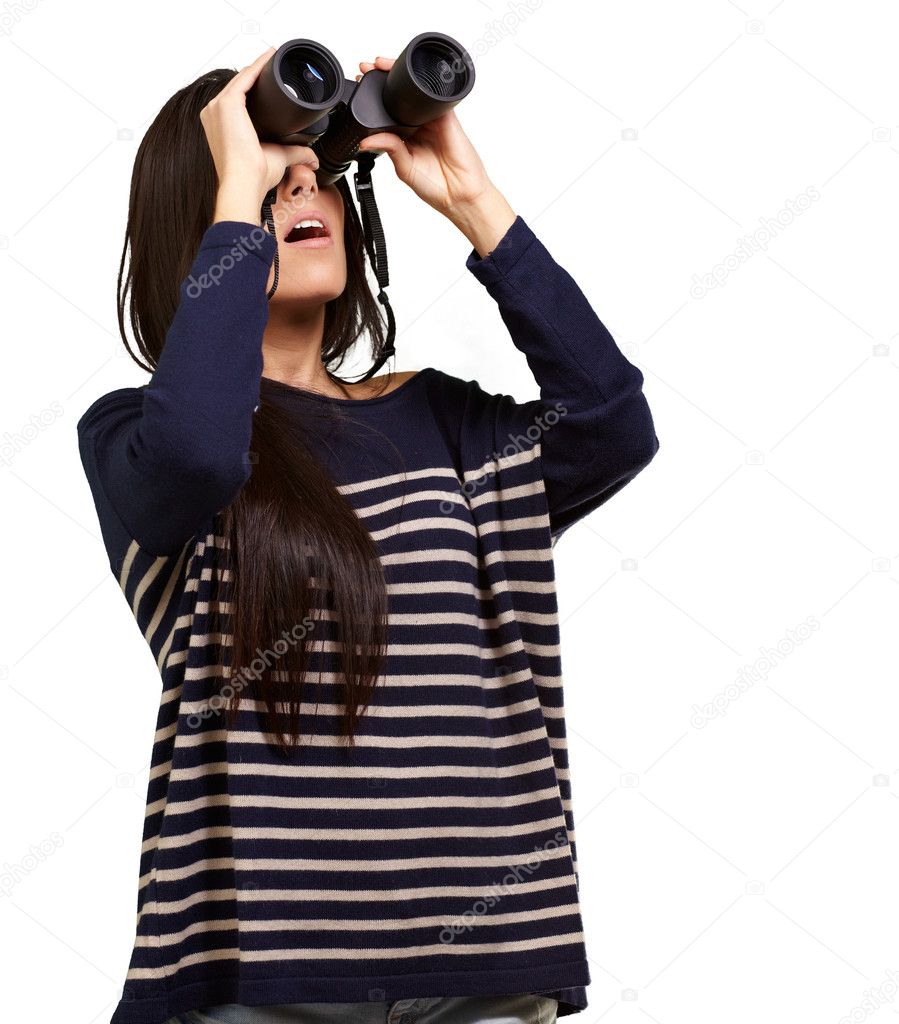 Portrait of young girl looking through a binoculars over white