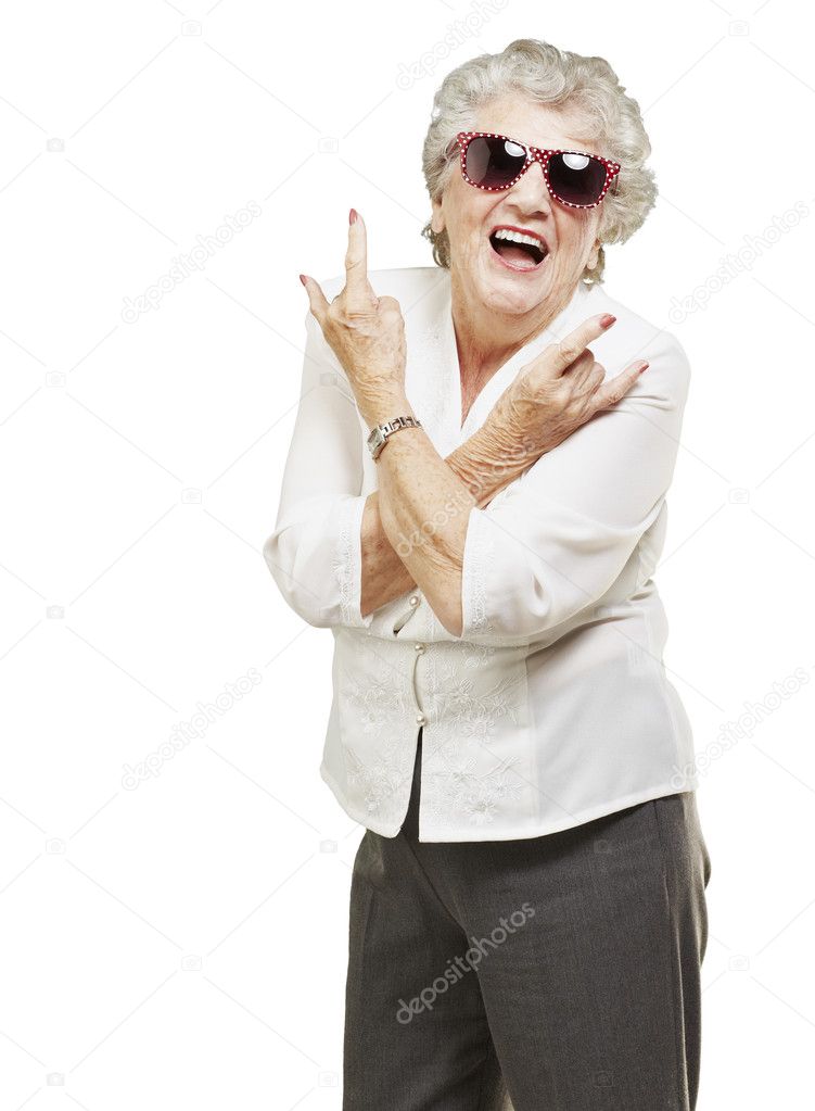 Portrait of senior woman doing rock symbol over white background