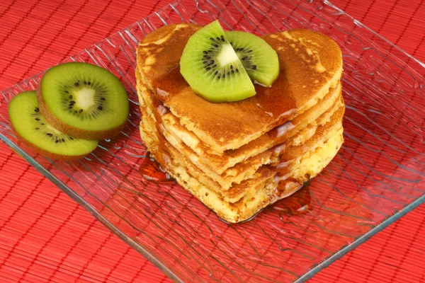 Heart-shaped pancakes with syrup and kiwi fruit — Stock Photo, Image