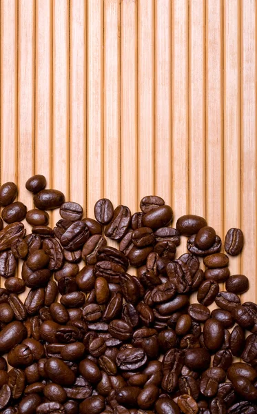Kaffeebohnen auf Bambus-Hintergrund — Stockfoto