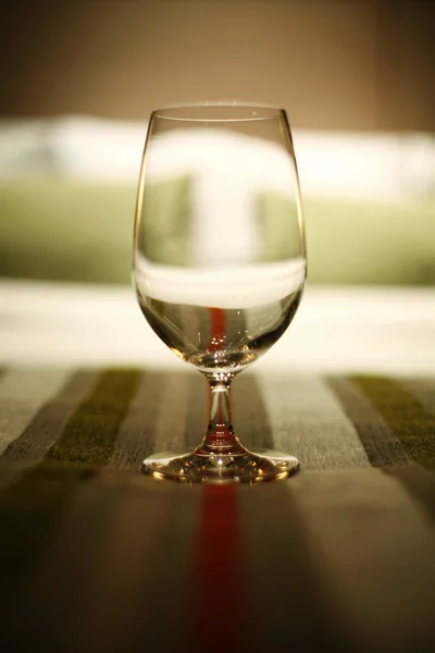 Stock image Wine glass on bed