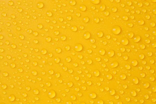 Water-druppels op geel — Stockfoto