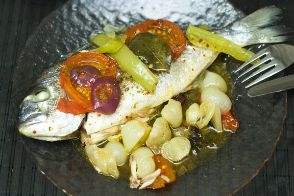 Fisk med grönsaker på en tallrik — Stockfoto