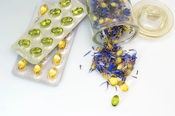 Herbal capsules and dried herbs cornflower — Stock Photo, Image