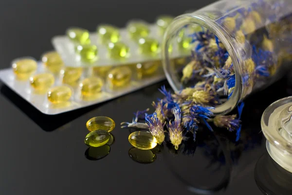 Herbal capsules and dried herbs cornflower — Stock Photo, Image