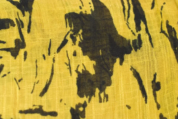 Zwarte patronen op een gele stof — Stockfoto