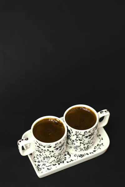 Turecká káva ve dvou šálků na černém pozadí — Stock fotografie