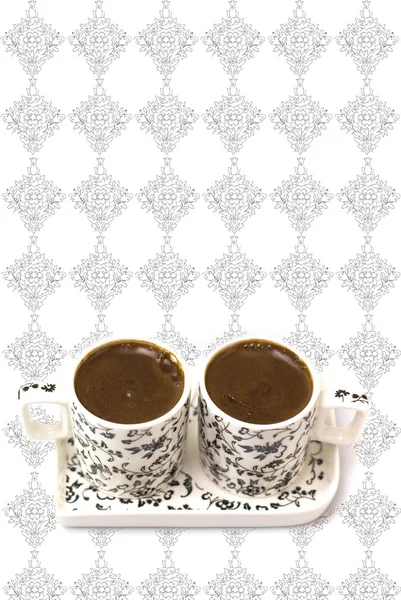 Café turco en dos tazas sobre fondo blanco con elementos negros — Foto de Stock