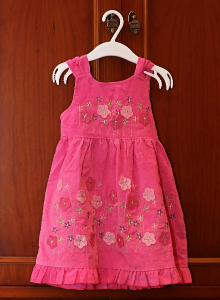 Baby rosa Kleid auf Kleiderbügel. lizenzfreie Stockfotos