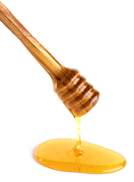 Honey flowing down from a wooden honey dipper — Stock Photo, Image