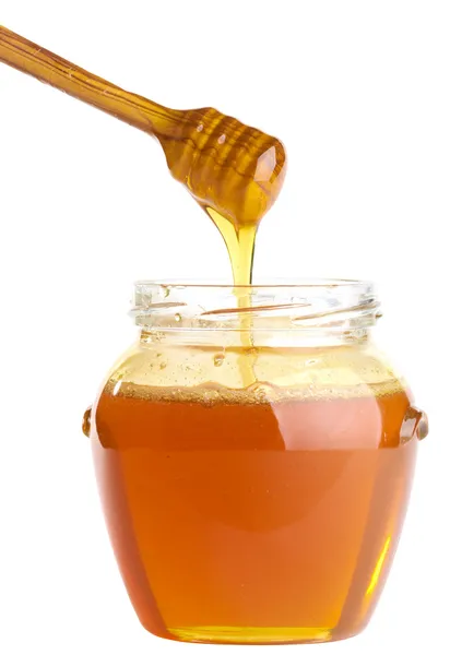 Δοχείο γεμάτο μέλι και κουτάλα Φωτογραφία Αρχείου