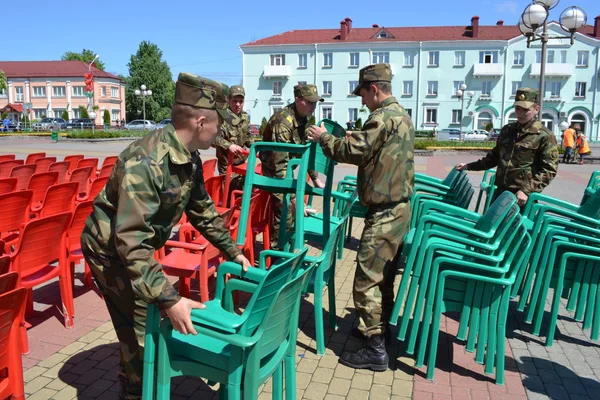 På en seger dagen holiday.soldiers bära bort stolar. — Stockfoto