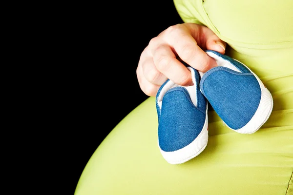 Raskaana oleva nainen vauvan kengät — kuvapankkivalokuva