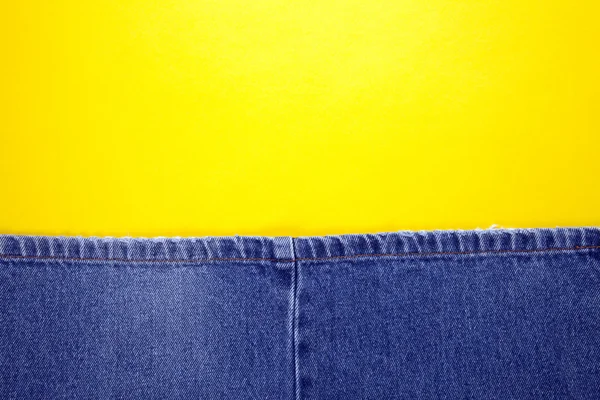 Blue jeans with yellow background — Stock Photo, Image