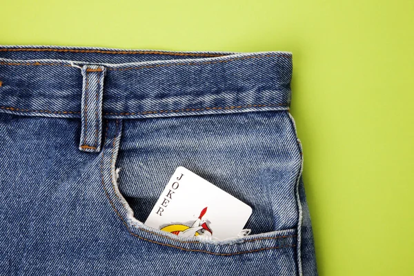 Playing card in blue jeans pocket — Stock Photo, Image