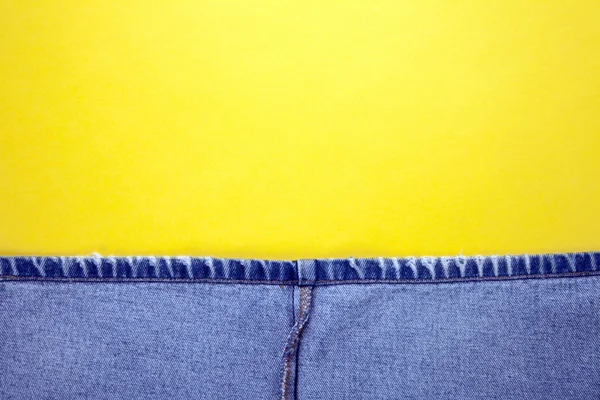 Niebieskie dżinsy z żółtym tle — Zdjęcie stockowe