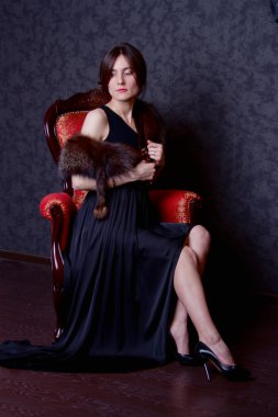 elbiseli kadın sandalyede oturuyor
