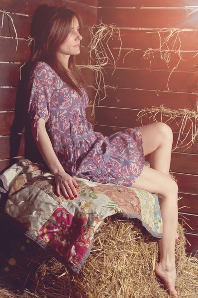 Menina bonita no vestido deitado atrás do feno — Fotografia de Stock