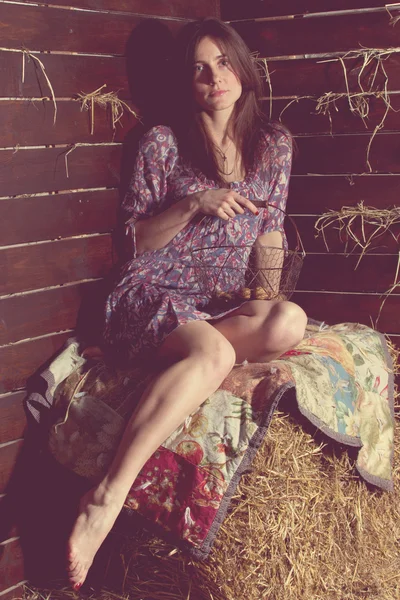Mooi meisje in jurk liggen achter hooi — Stockfoto