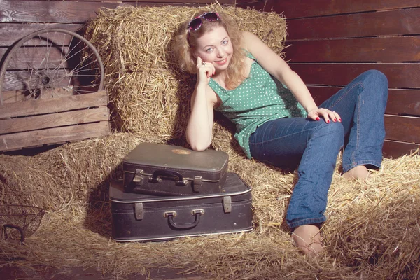 Κορίτσι στο σανό κοντά τις αποσκευές — Φωτογραφία Αρχείου