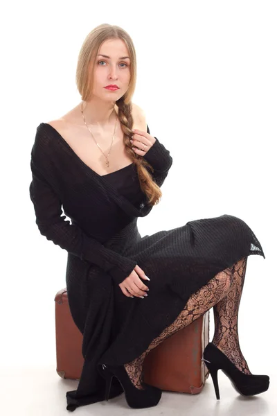 Kobieta siedzi na stare skórzane etui — Zdjęcie stockowe
