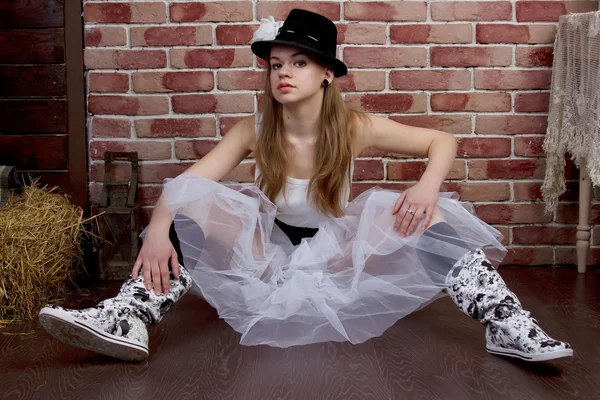Fashionabla ung kvinna poserar i en tegelvägg. — Stockfoto