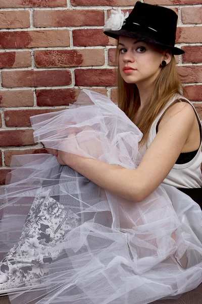 Модна молода жінка позує на цегляну стіну . — стокове фото