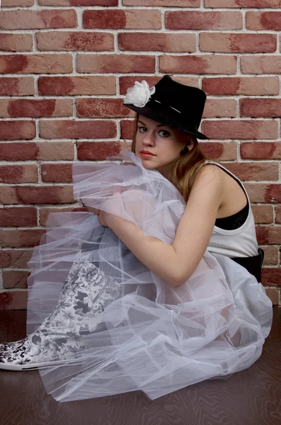 Fashionable young woman posing of a brick wall. — Stock Photo, Image