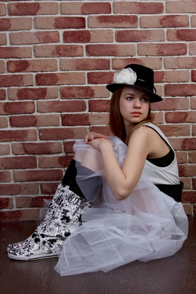 Fashionabla ung kvinna poserar i en tegelvägg. — Stockfoto