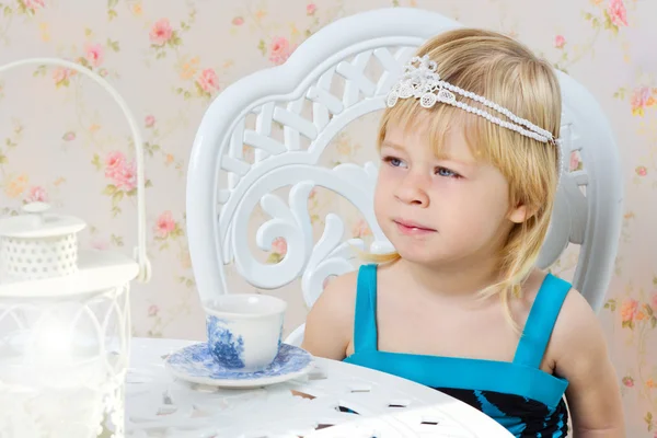 Маленькая девочка в красивом платье пьет чай — стоковое фото