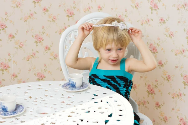 Bir sandalyede oturan elbiseli küçük kız — Stok fotoğraf