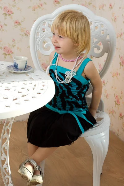 在一件衣服，坐在旁边的窗口与单元格的小女孩 — 图库照片