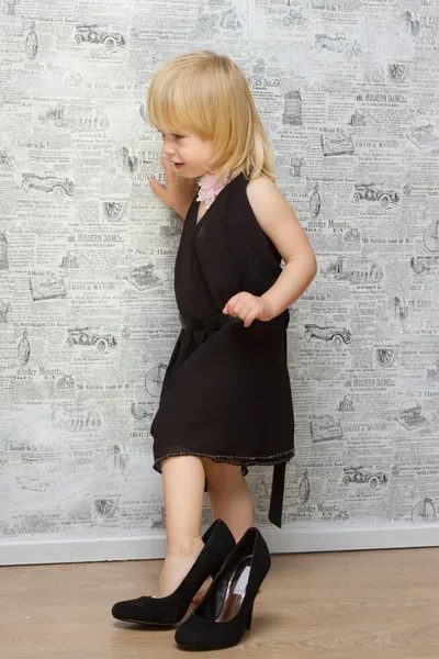 Den lilla flickan mäter mammas skor med klack — Stockfoto