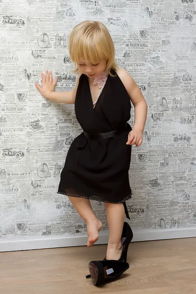 Malá holčička měří matčiny boty s podpatky — Stock fotografie