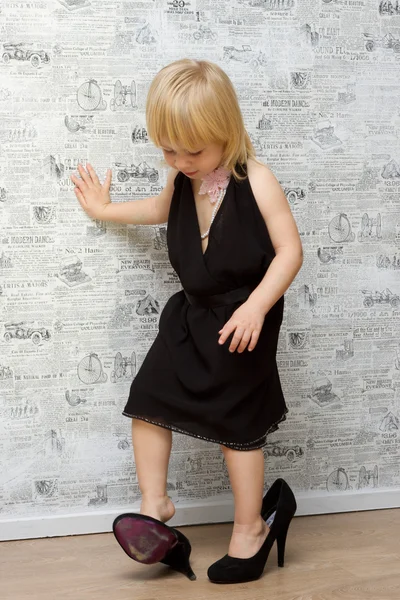 Den lilla flickan mäter mammas skor med klack — Stockfoto