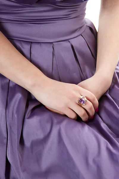 Händerna på en tjej med en lila ring på klänningen — Stockfoto