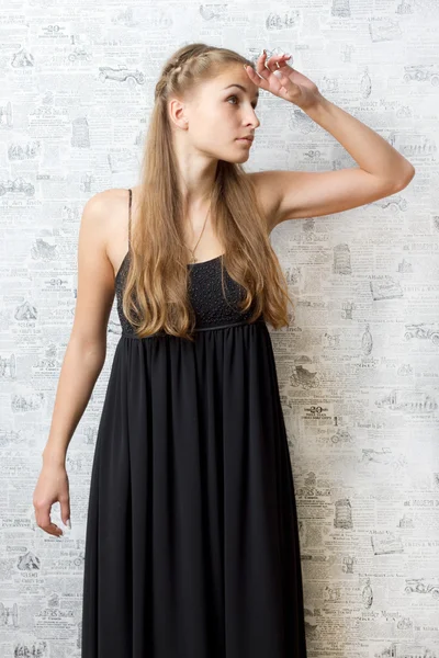 Bella ragazza in un vestito vicino al muro — Foto Stock