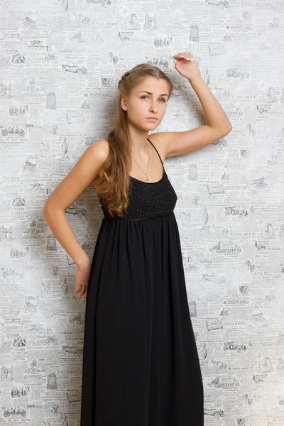 Hermosa chica en un vestido cerca de la pared — Foto de Stock