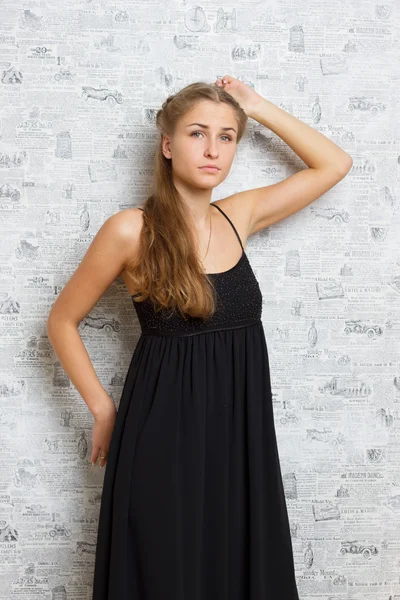 Smuk pige i en kjole nær væggen - Stock-foto