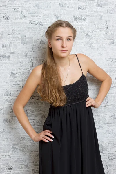 Hermosa chica en un vestido cerca de la pared —  Fotos de Stock