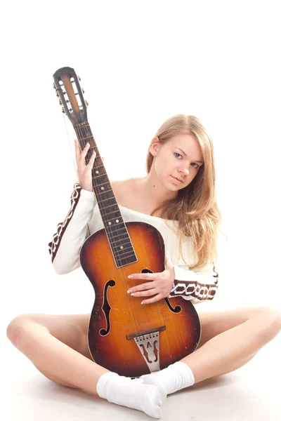 Красивая девушка в свитере с гитарой — стоковое фото