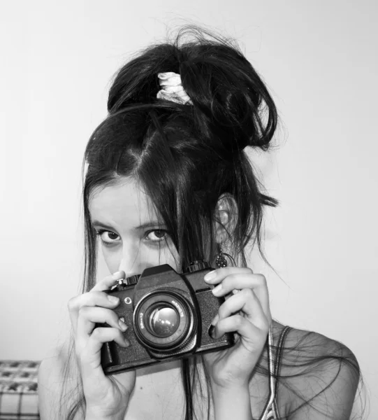 Chica joven sosteniendo una cámara Imágenes de stock libres de derechos