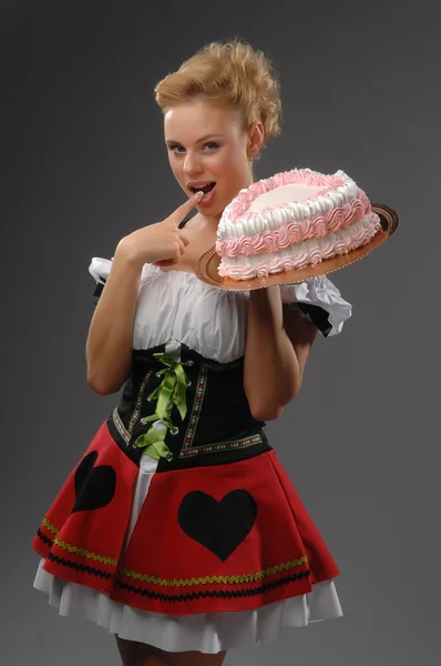 A woman in a corset and a cake — Stock Photo, Image