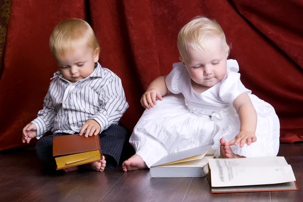Kinder lesen Bücher auf dem Boden sitzend gegen — Stockfoto